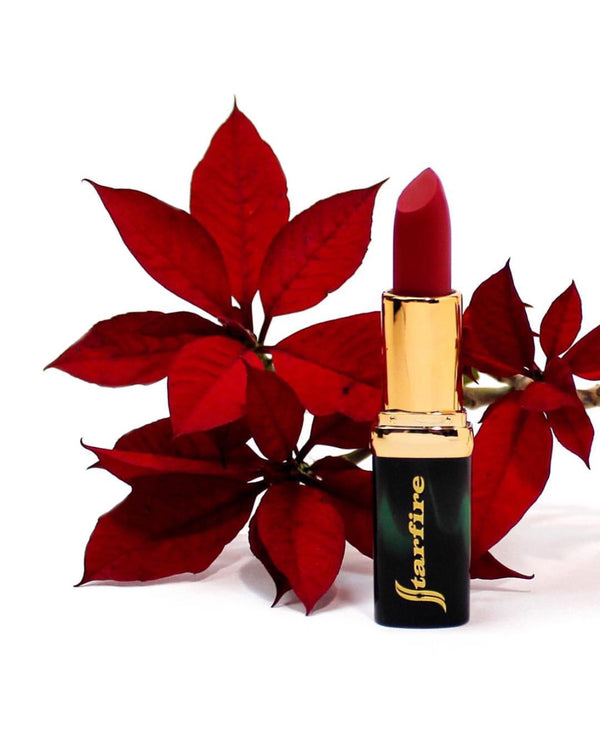 red matte velvet lipstick in gold tube next to red flower-starfire cosmetics