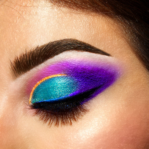 women with eyes closed wearing eyeshadow makeup colors, green, purple, yellow, and gold-starfire cosmetics