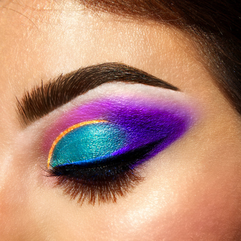 women with eyes closed wearing eyeshadow makeup colors, green, purple, yellow, and gold-starfire cosmetics